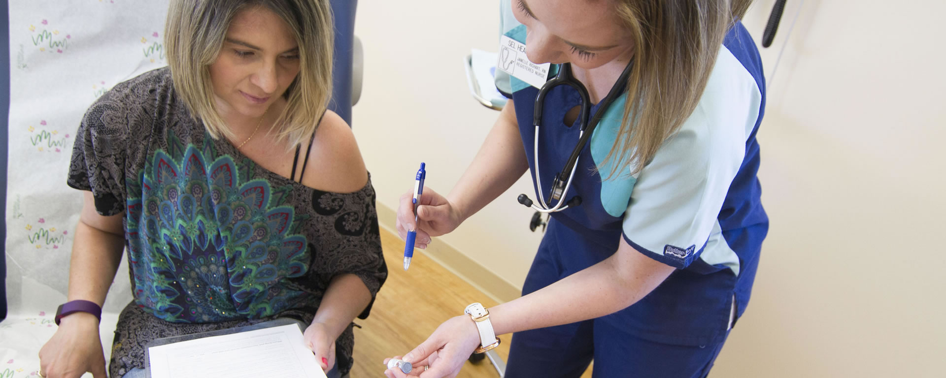patient filling out form with nurse